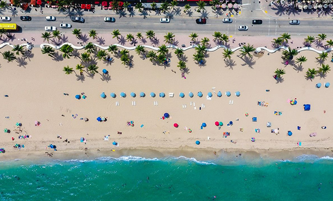 Overhead view of a beach with blue umbrellas