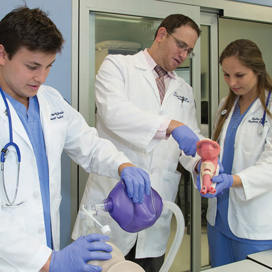 Students performing a procedure on medical dummy